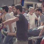 Civilians Carry Wounded Out of the Crowd